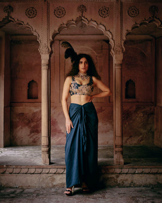 Model showcasing blue floral zardosi work crop top with plan blue pre-drap skirt with knot.