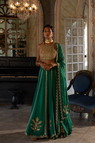 Featuring an emerald green hand embroidered lehenga paired with an organza base dupatta heavily highlighted using gold dori and a mirror embellished blouse.