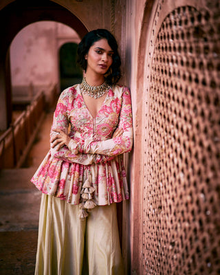 The close up view of a modern peplum set in P&H floral printswith yoke and sleeves are hand-embroidered in zardozi flowers and sequins with tassel detailing