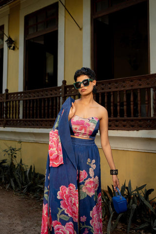 The front look of the floral print in crepe tube top with knot (blouse), pant with Jacket holding in her hand.