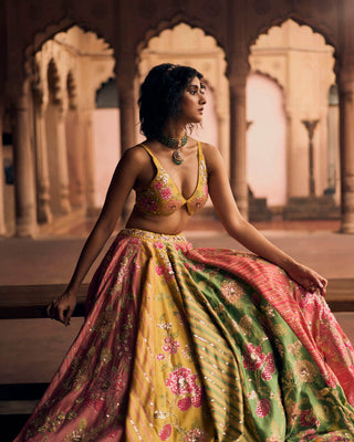 Close up look of the An ode to Rajasthan, in shades of Tuscany yellow, hot pink, onion pink and apple green. It features a signature cut statement blouse with delicate embroidery and rajasthani leheriya lehenga.