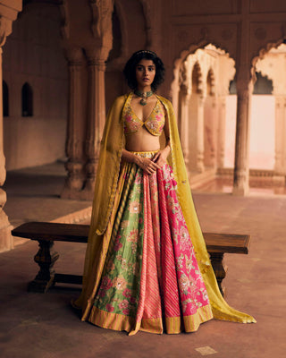 An ode to Rajasthan, in shades of Tuscany yellow, hot pink, onion pink and apple green. It features a signature cut statement blouse blouse with delicate embroidery and a scallop embroidered organza dupatta with butti all over. Our lehenga is crafted from beautiful combination of lehriya and floral print and it is fully hand embroidered using, sequins, cutdana, zari and resham.